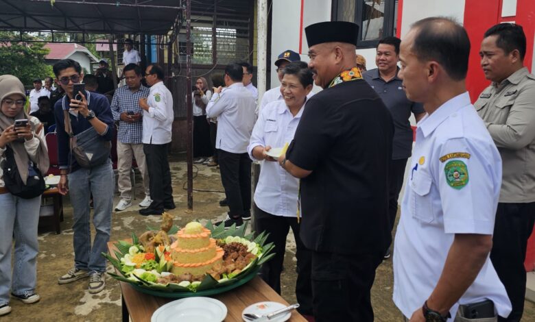prosesi pemotongan nasi tumpeng, yang dilakukan oleh Bupati Edi Damansyah bersama Pelaksana Tugas (Plt) Lurah setempat.