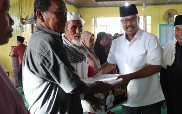 Bupati Kukar, Edi Damansyah, membagikan bingkisan kepada masyarakat dan peralatan ibadah untuk takmir Masjid An Nur Desa Tani Baru.